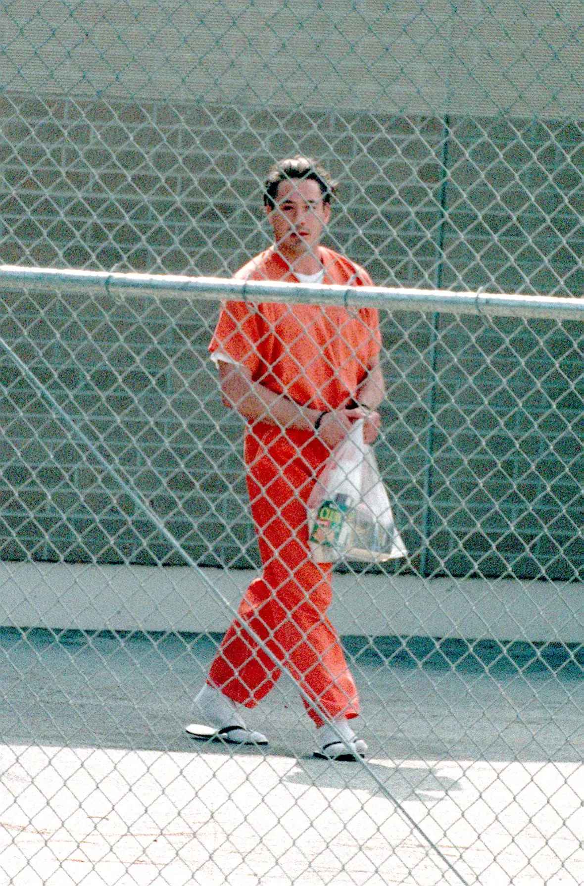 Robert Downey Jr. na cestě do vězeňského autobusu po soudním jednání 5. srpna 1999 v Malibu v Kalifornii. Tento den byl propuštěn na kauci 15 000 dolarů.